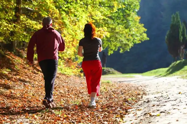 Personas caminando en un campo para disfrutar los beneficios de caminar